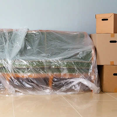 Cajas de mudanza y sofá embalado para el vaciado de un inmueble.